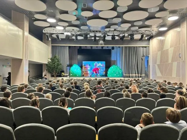 Полный зал детей на выездном спектакле театра